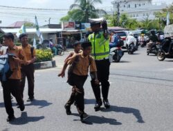 Strong Poin Siang, Polantas Lhokseumawe Bantu Siswa Pulang Sekolah Menyeberang Jalan